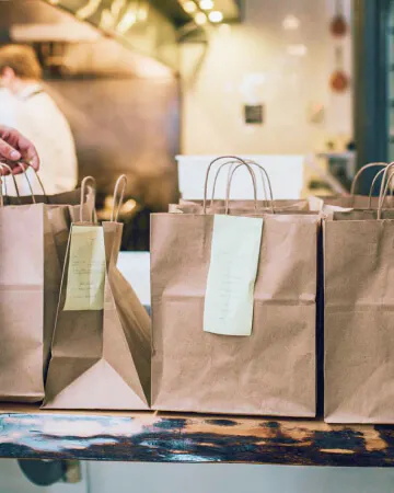 Several bagged orders of food to-go