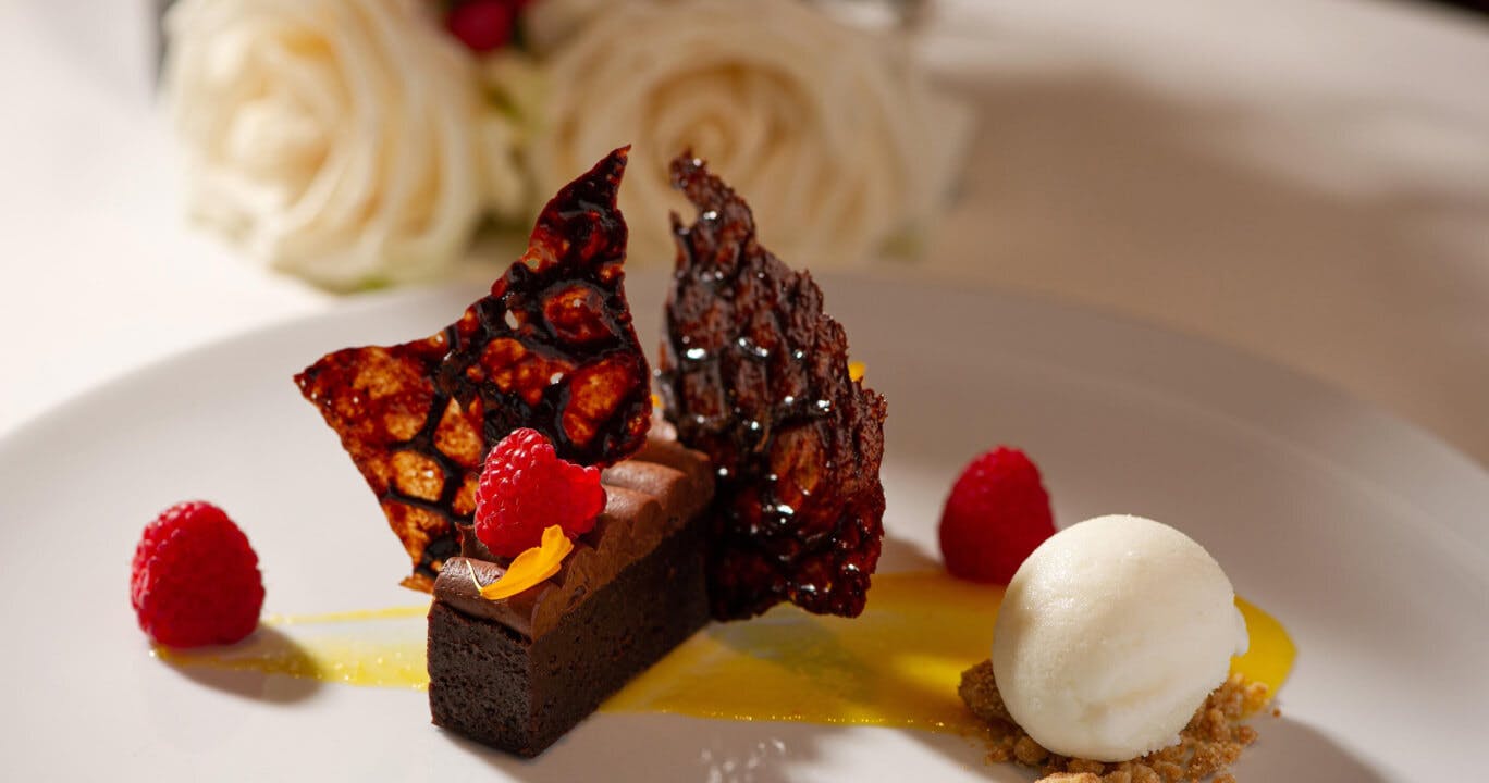 Bacchus Restaurant & Lounge - elegant dessert with white roses in the background