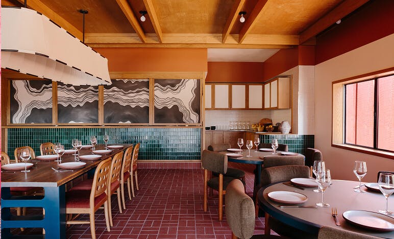 Oliver Hospitality - colorful green and red restaurant interior with tables and chairs