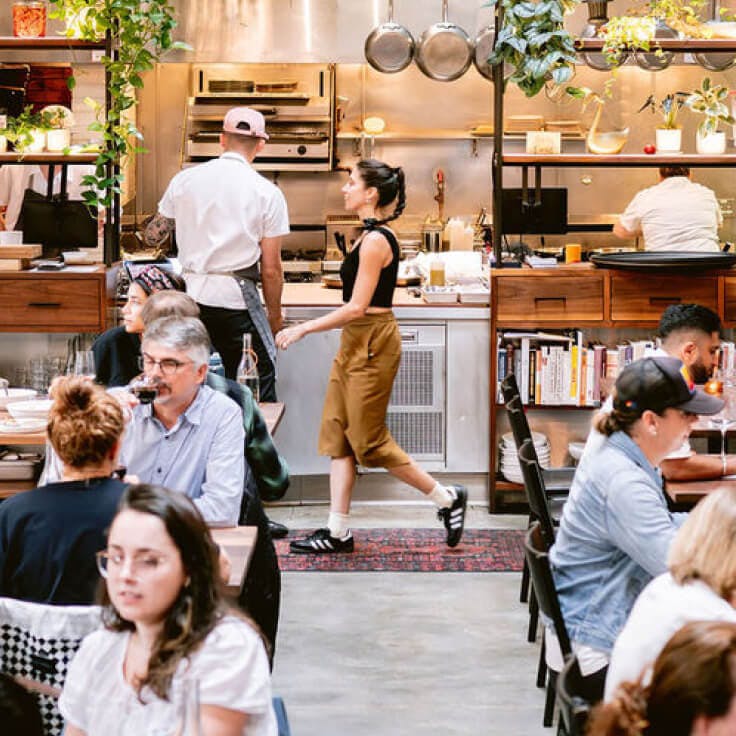 Flour + Water restaurant interior with a server walking through the dining room