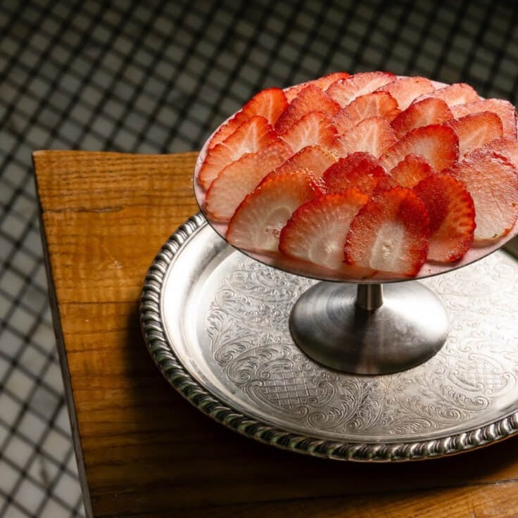 Rose's Luxury plated dessert with carefully sliced strawberries on an elevated dish