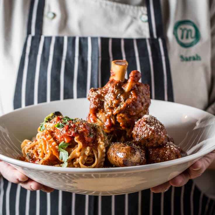 Monteverde plated Osso Bucco dish with server presenting the dish