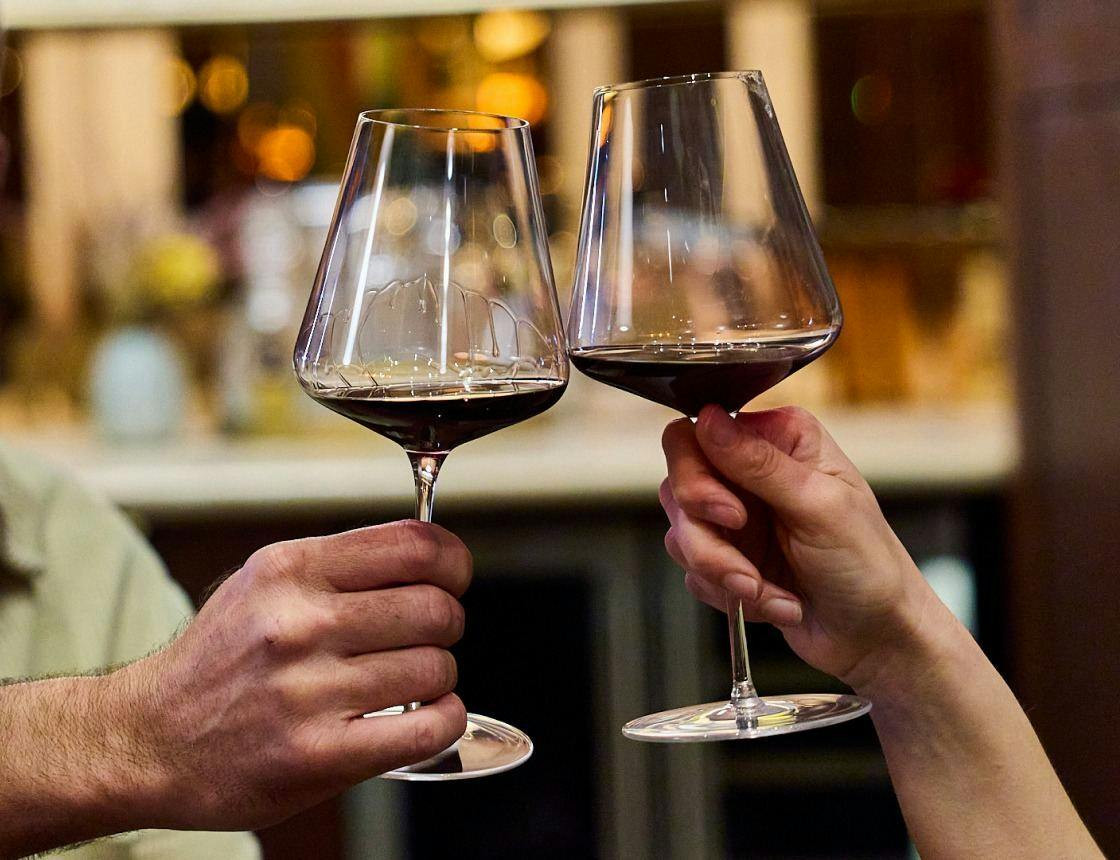 friends tapping glasses tasting wine at a winery