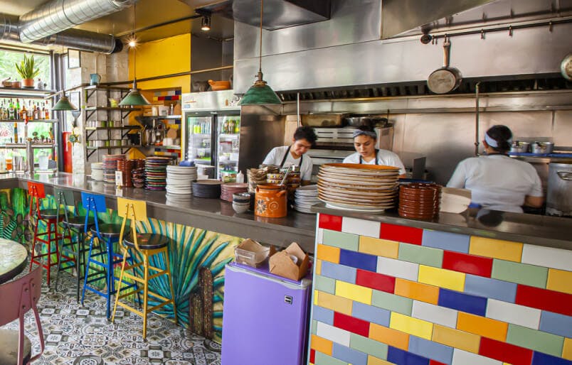 Chefs preparing food with natural light in an open kitchen
