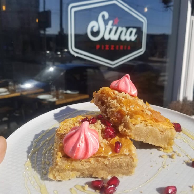 Stina - Philadelphia, PA - plated dessert on a sunny patio with Stina signage on an exterior window