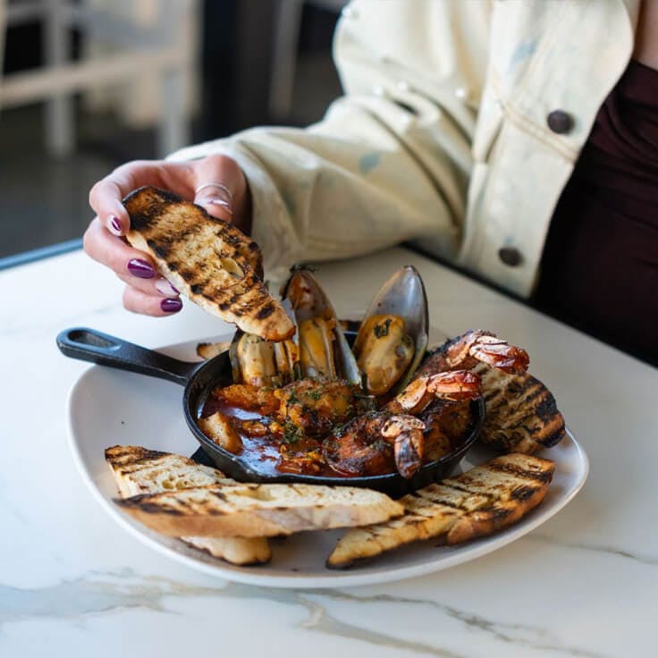 Plated dish with shrimp and bread from Nook Kitchen