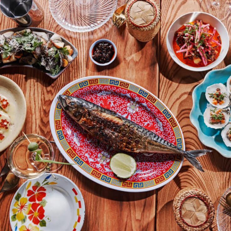 Several plated dishes from Talat Market with a whole fish as the centerpiece