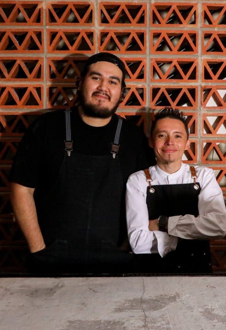 Two chefs embracing for a photo opportunity