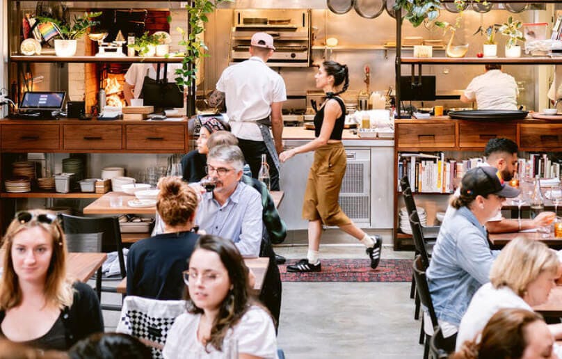 Chefs preparing food with natural light in an open kitchen